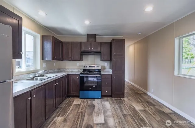 a kitchen with stainless steel appliances granite countertop a refrigerator stove and sink