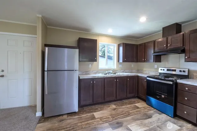 a view of a kitchen with a refrigerator cabinets and wooden floor