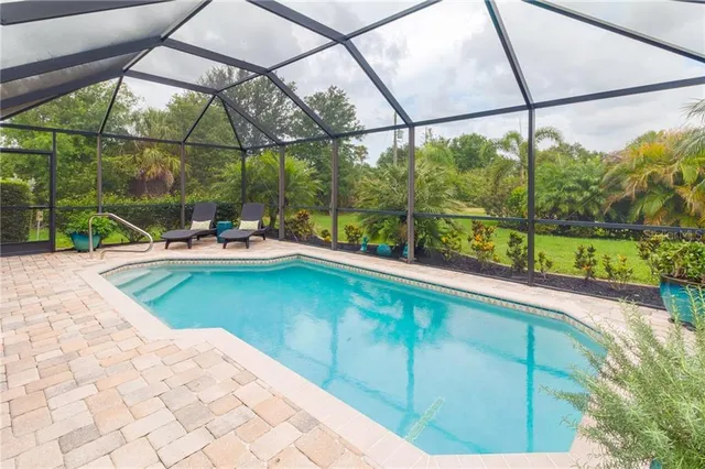 a swimming pool with lawn chairs and outdoor view