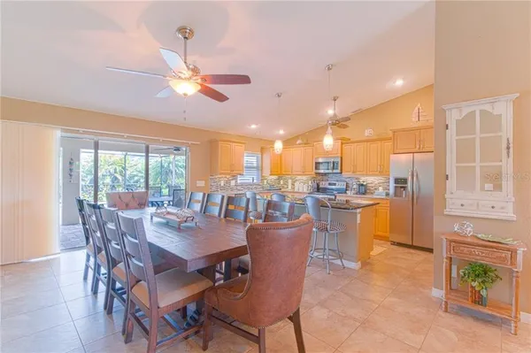 a dining room with furniture a kitchen view and a chandelier
