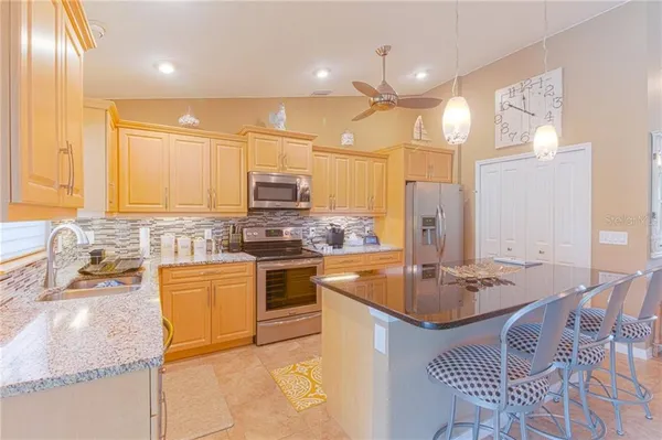 a kitchen with stainless steel appliances granite countertop a sink stove and refrigerator