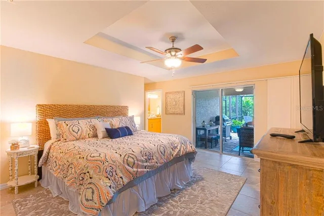 a bedroom with a bed a large window with table and chairs