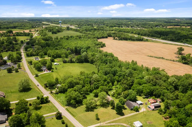 an aerial view of residential houses with outdoor space and trees