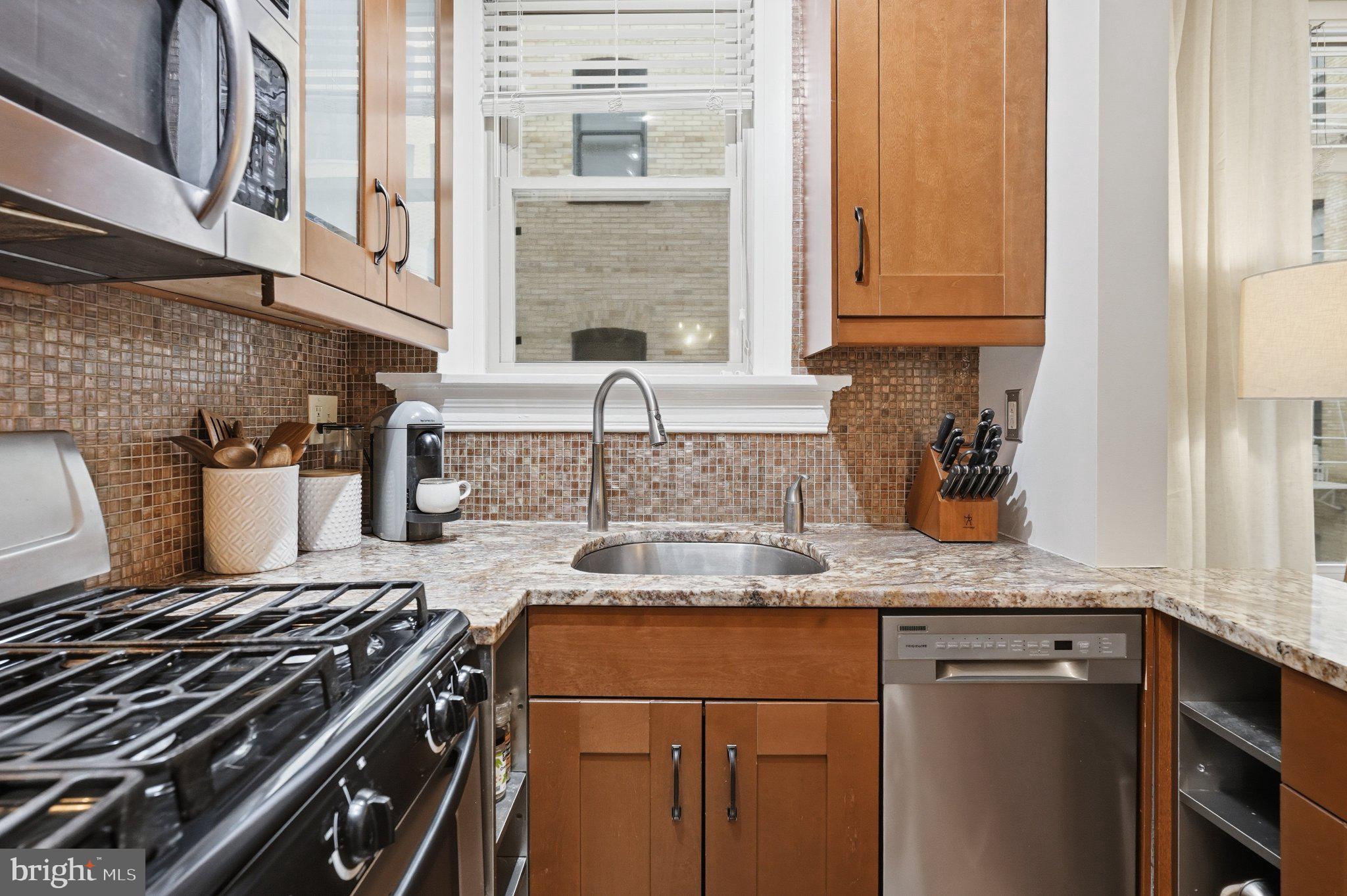 2010 Kalorama Road Northwest, Unit 304 Washington, DC 20009 - Photo 11 of 23 a kitchen with granite countertop a sink stove and cabinets
