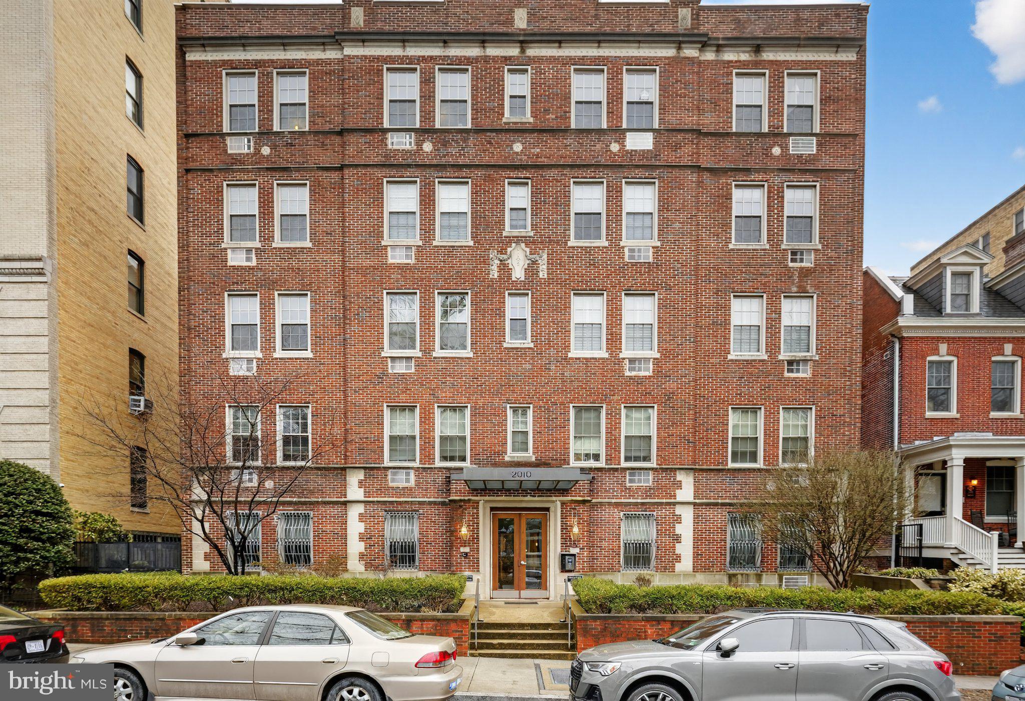 2010 Kalorama Road Northwest, Unit 304 Washington, DC 20009 - Photo 2 of 23 a front view of a building with lot of cars and trees