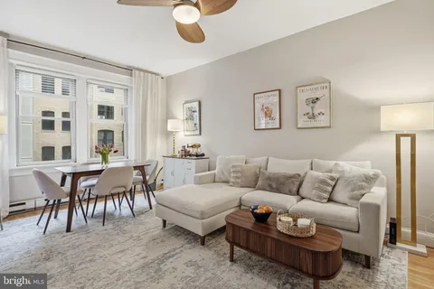 a living room with furniture a dining table and a large window
