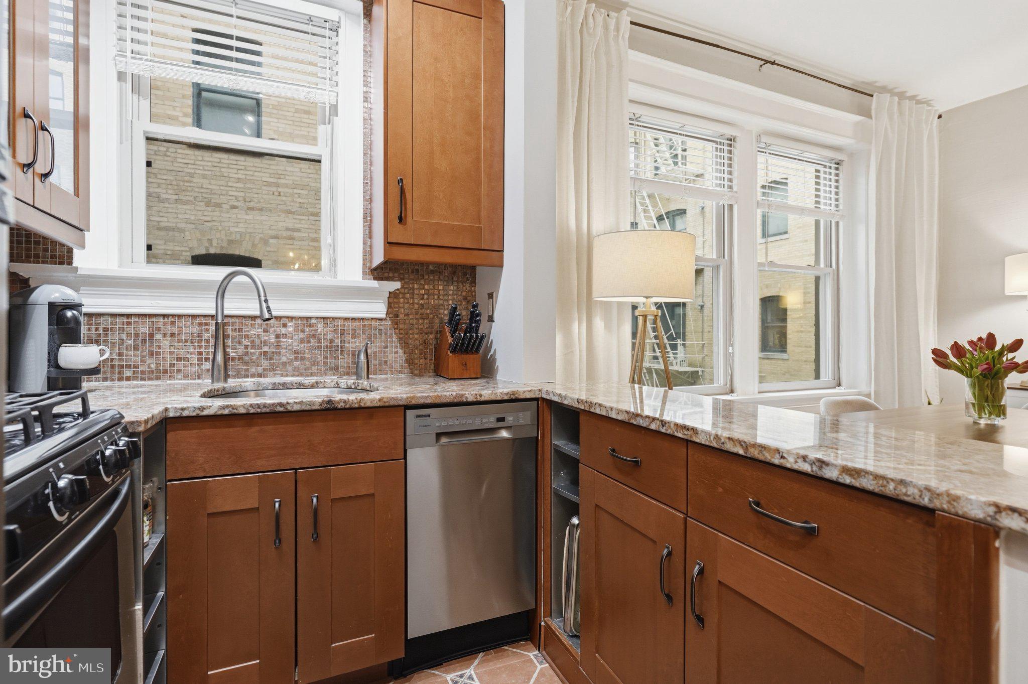 2010 Kalorama Road Northwest, Unit 304 Washington, DC 20009 - Photo 10 of 23 a kitchen with granite countertop cabinets stainless steel appliances a sink and a window