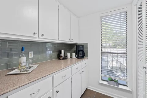 a kitchen with granite countertop white cabinets and white appliances
