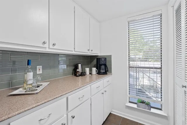 a kitchen with granite countertop white cabinets and white appliances