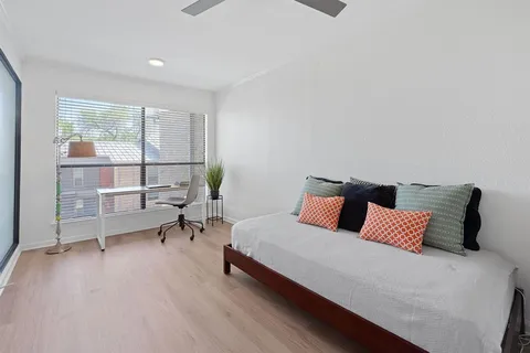 a bedroom with a bed a lamp and window