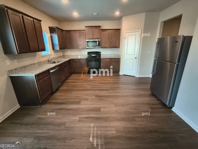 a kitchen with stainless steel appliances granite countertop a refrigerator stove microwave and sink