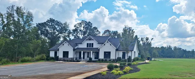 a front view of a house with garden and trees