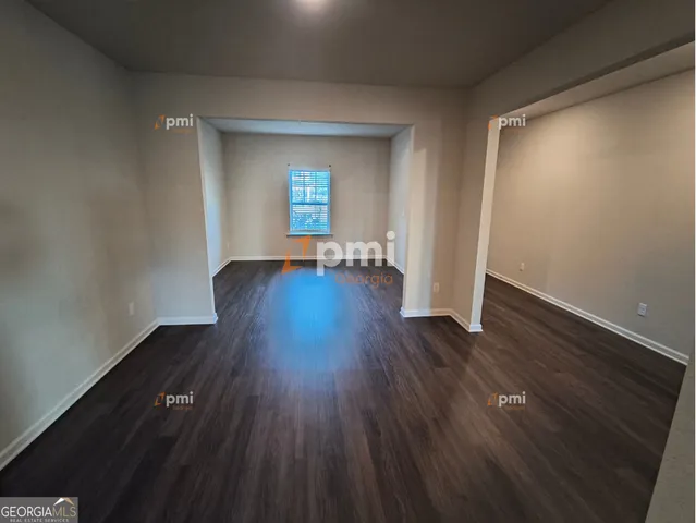 a view of empty room with wooden floor and window