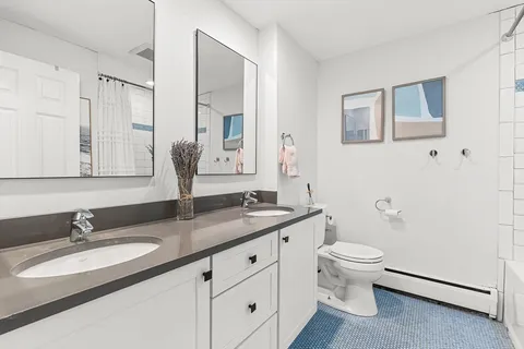 a bathroom with a granite countertop sink mirror and toilet
