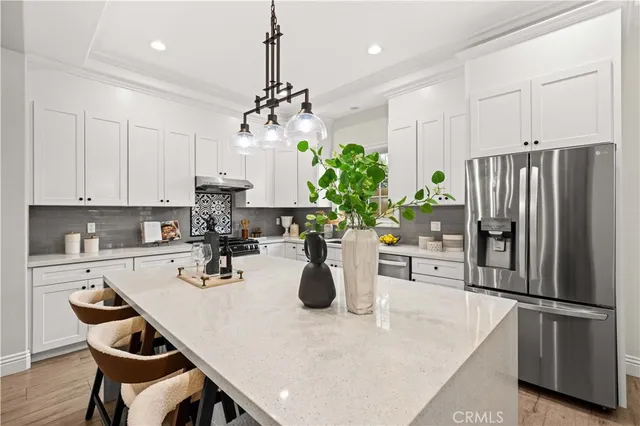 a kitchen with a stove a sink and white cabinets