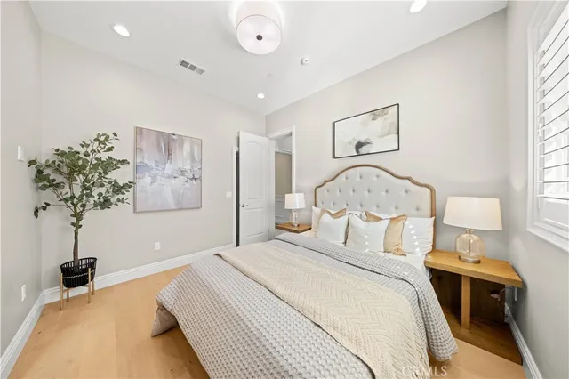 a bedroom with a bed and a potted plant