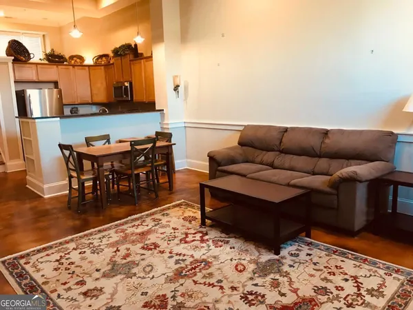a living room with furniture a rug and a table