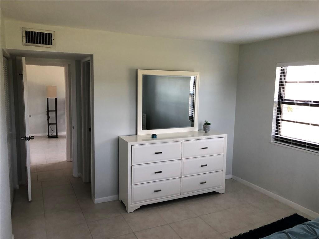 9370 Southwest 8th Street, Unit 323 Boca Raton, FL 33428 - Photo 11 of 17 a bathroom with a double vanity sink and mirror
