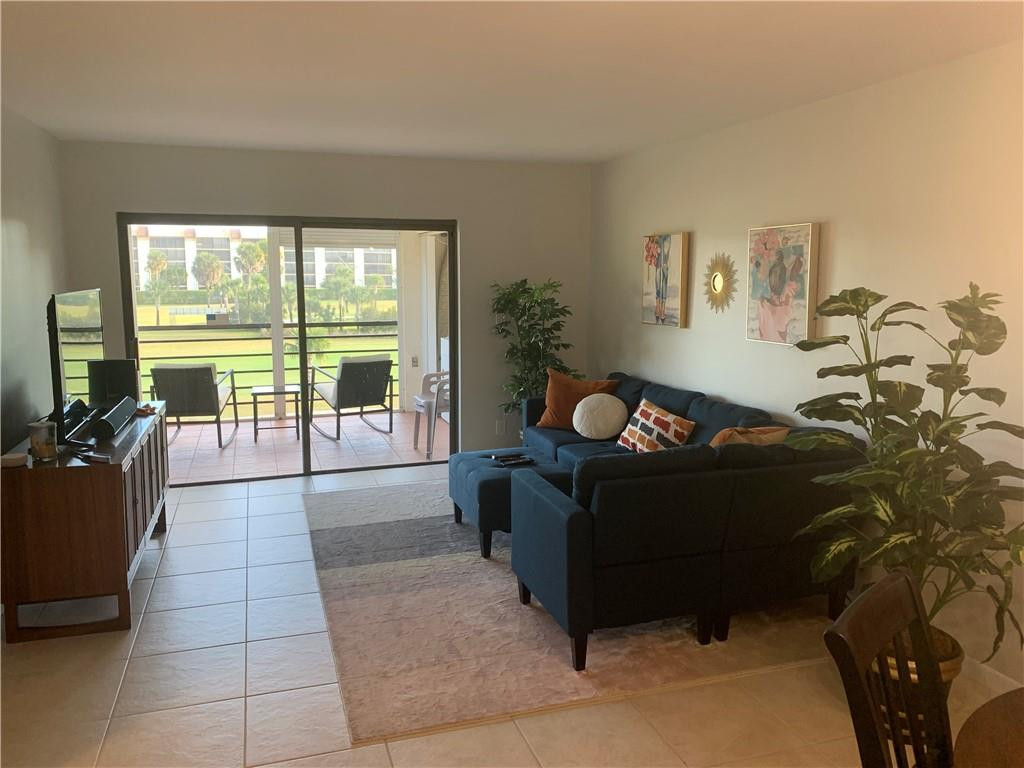 9370 Southwest 8th Street, Unit 323 Boca Raton, FL 33428 - Photo 14 of 17 a living room with furniture and a floor to ceiling window
