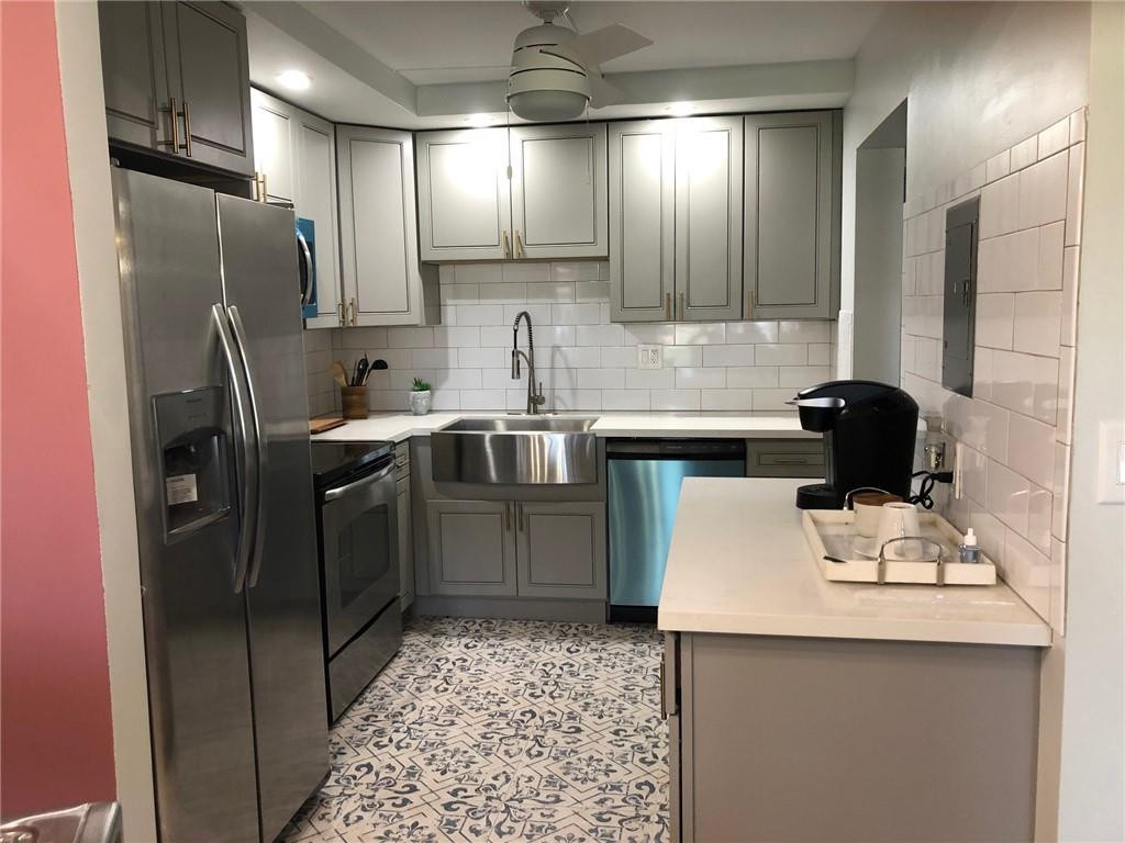 9370 Southwest 8th Street, Unit 323 Boca Raton, FL 33428 - Photo 4 of 17 a kitchen with stainless steel appliances a sink stove and refrigerator