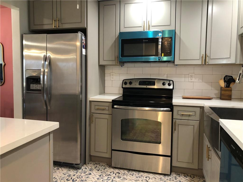 9370 Southwest 8th Street, Unit 323 Boca Raton, FL 33428 - Photo 9 of 17 a kitchen with stainless steel appliances granite countertop a stove a refrigerator and a microwave