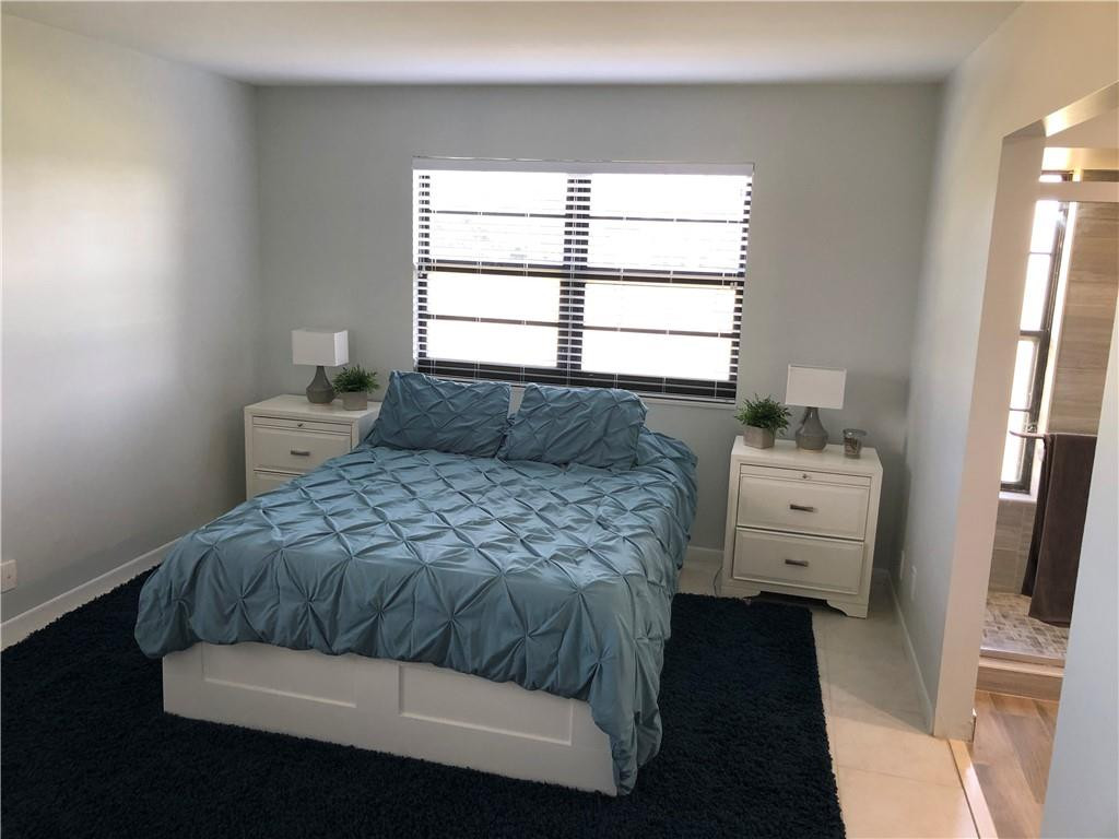 9370 Southwest 8th Street, Unit 323 Boca Raton, FL 33428 - Photo 10 of 17 a bedroom with a bed and a window