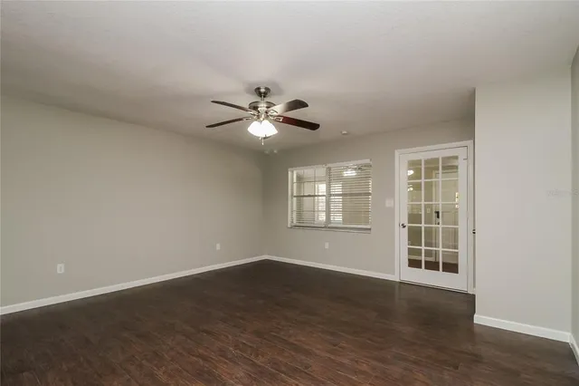 a view of wooden floor and a chandelier fan in a room