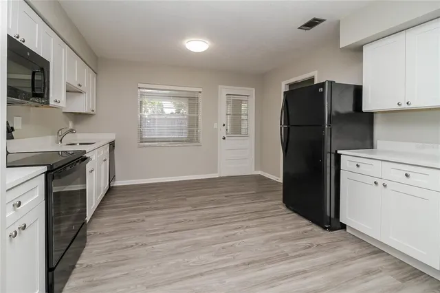 a kitchen with granite countertop a refrigerator stove and sink