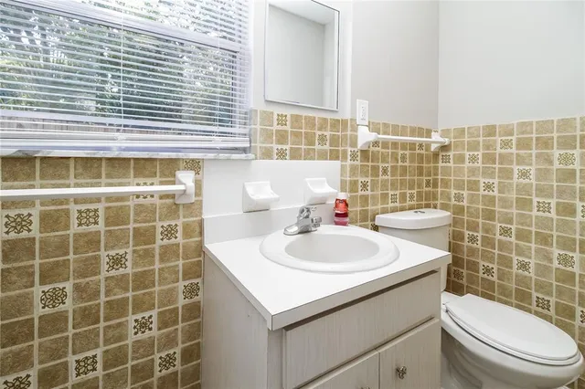 a bathroom with a sink a toilet and a mirror