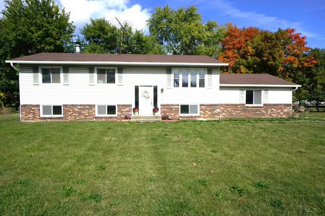 a view of a house with a yard and sitting area