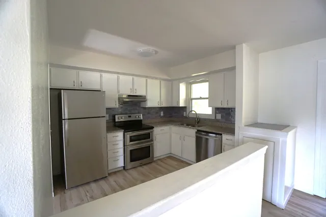 a kitchen with a refrigerator stove and sink