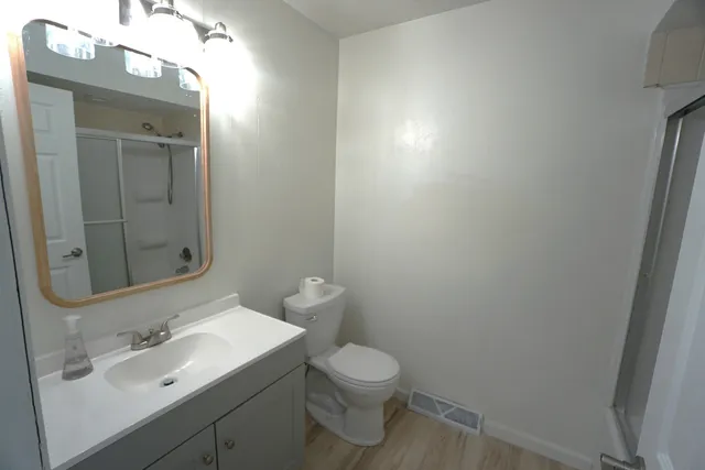 a bathroom with a toilet a sink and mirror