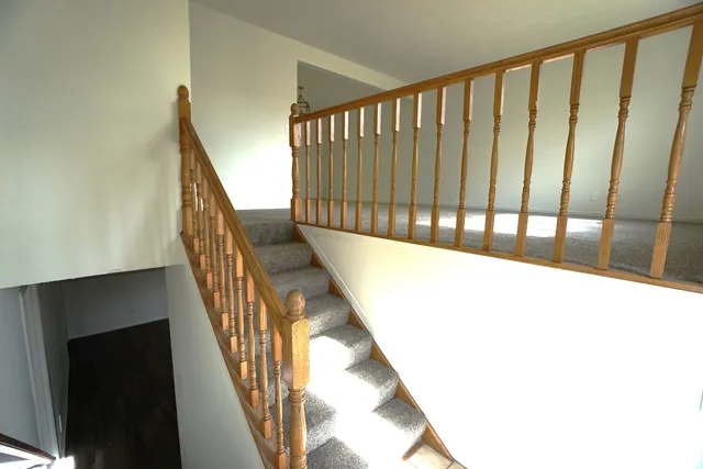 a view of staircase with wooden floor and white walls