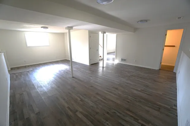 a view of a room wooden floor and a window