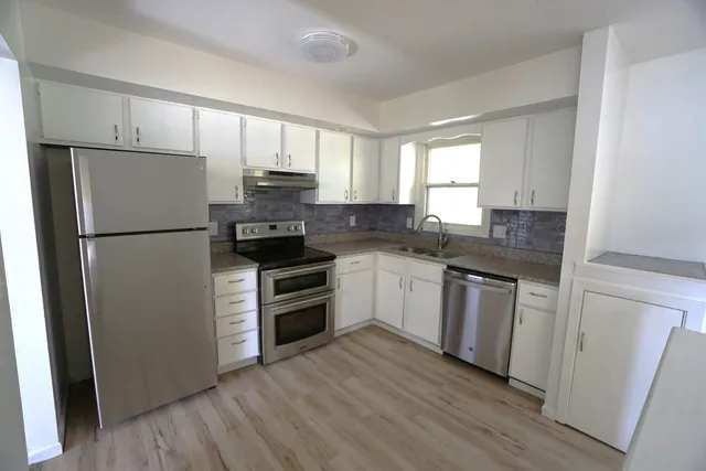a kitchen with a refrigerator stove and sink