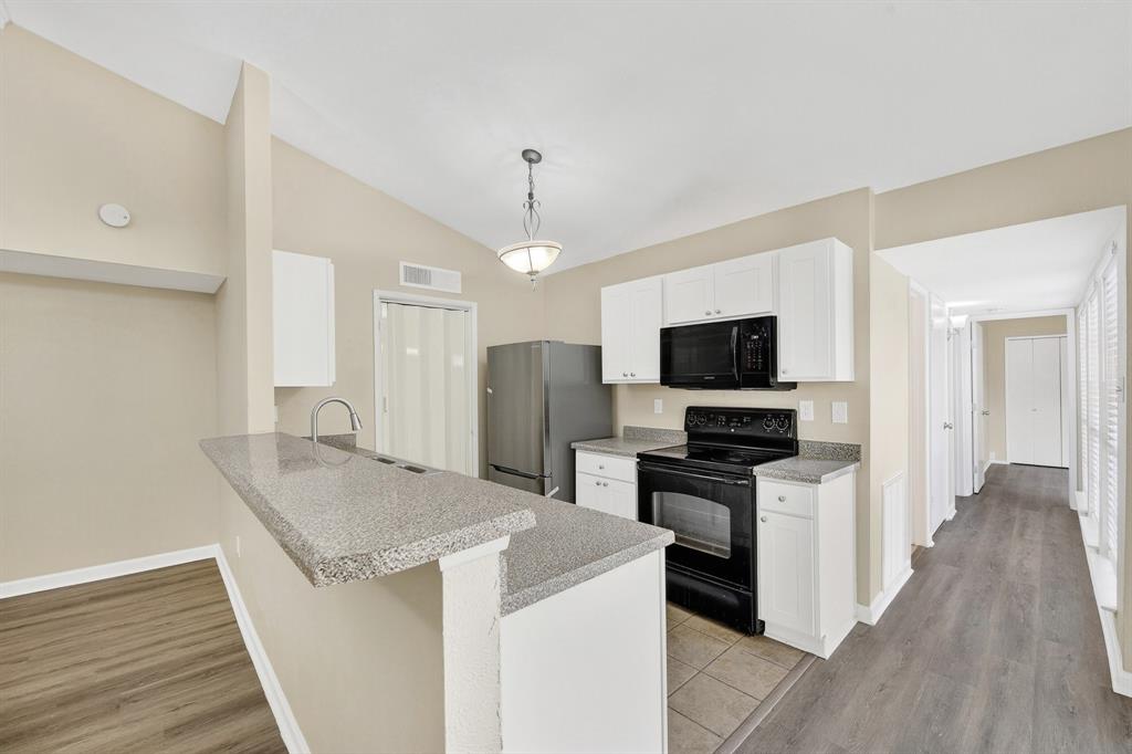 6018 McAfee Drive The Colony, TX 75056 - Photo 11 of 28 a kitchen with stainless steel appliances granite countertop a stove top oven a sink dishwasher and a refrigerator with wooden floor