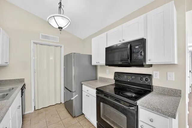 a kitchen with stainless steel appliances granite countertop a stove microwave and refrigerator