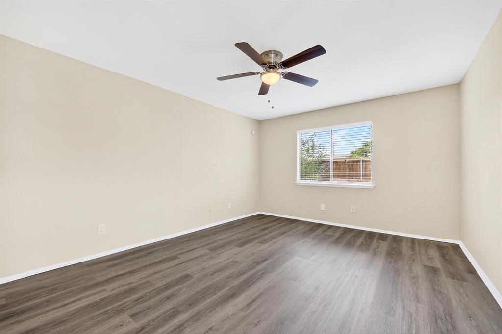 6018 McAfee Drive The Colony, TX 75056 - Photo 19 of 28 an empty room with wooden floor fan and windows