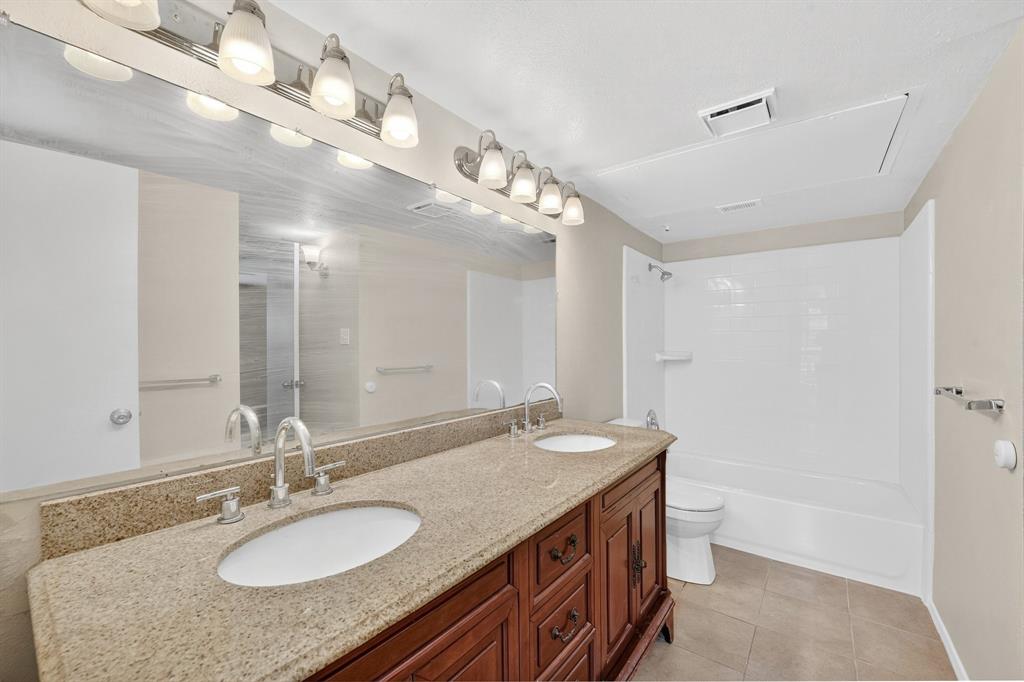 6018 McAfee Drive The Colony, TX 75056 - Photo 20 of 28 a bathroom with a granite countertop double vanity and a mirror