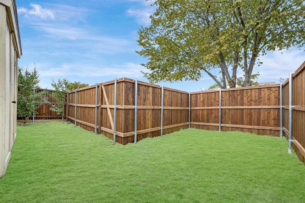 6018 McAfee Drive The Colony, TX 75056 - Photo 25 of 28 a view of a backyard with wooden fence and a large tree