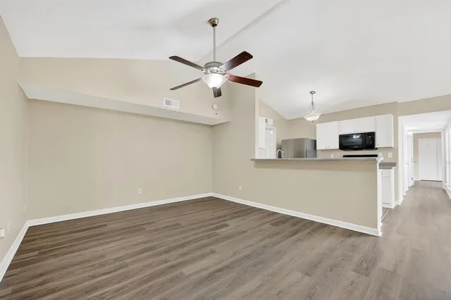 a view of a kitchen with wooden floor and a ceiling fan