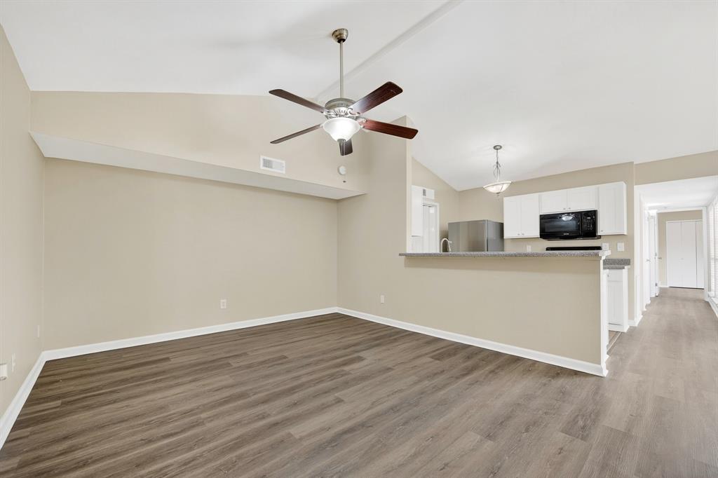6018 McAfee Drive The Colony, TX 75056 - Photo 4 of 28 a view of a kitchen with wooden floor and a ceiling fan
