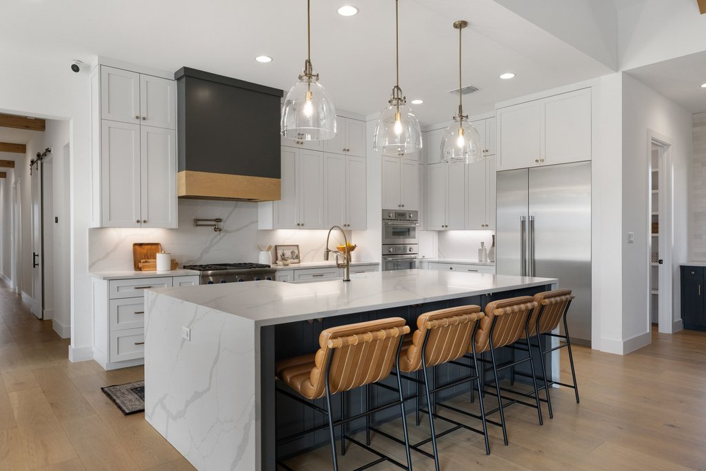 6316 Caudill Lane Austin, TX 78738 - Photo 12 of 40 a kitchen with stainless steel appliances granite countertop a sink a stove a refrigerator and island with wooden floor