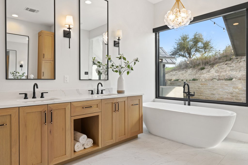 6316 Caudill Lane Austin, TX 78738 - Photo 16 of 40 a spacious bathroom with a double vanity sink a mirror a bathtub and