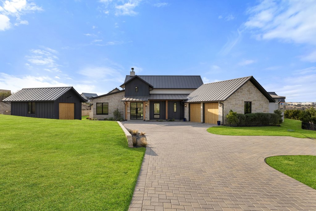 6316 Caudill Lane Austin, TX 78738 - Photo 3 of 40 View of front facade featuring a front lawn, a standing seam roof, an outbuilding, decorative driveway, and a chimney