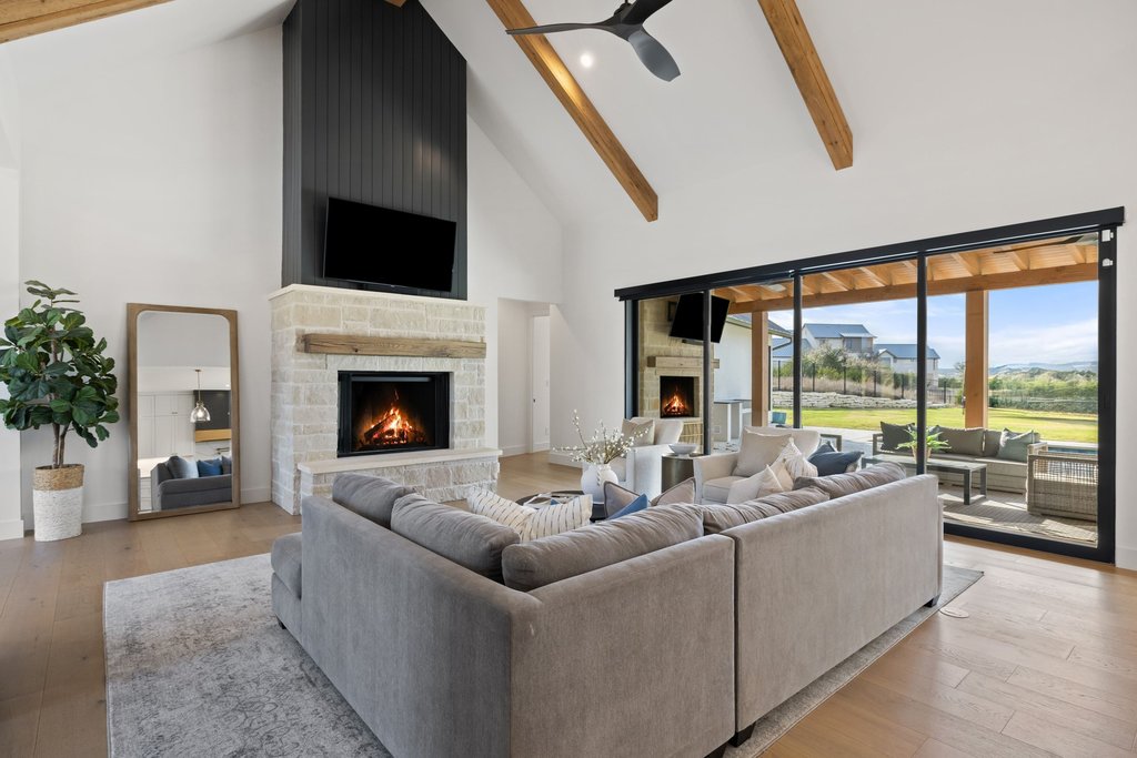 6316 Caudill Lane Austin, TX 78738 - Photo 6 of 40 Living room featuring a fireplace, light wood-style floors, ceiling fan, and lofted ceiling