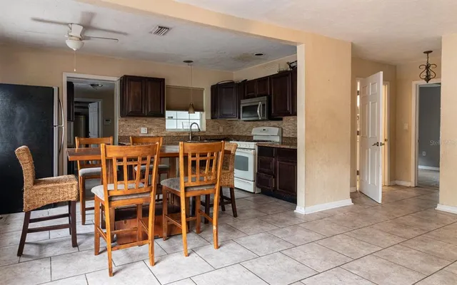 a kitchen with stainless steel appliances wooden cabinets a stove top oven a sink and dishwasher