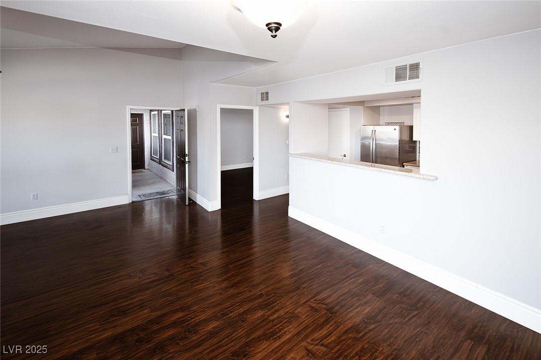 7255 West Sunset Road, Unit 2090 Las Vegas, NV 89113 - Photo 17 of 31 Unfurnished living room with baseboards, visible vents, and dark wood-type flooring