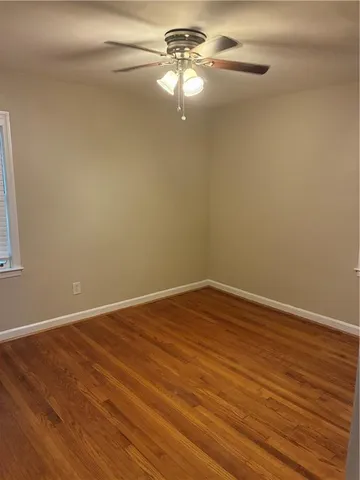 a view of a room with wooden floor and a ceiling fan