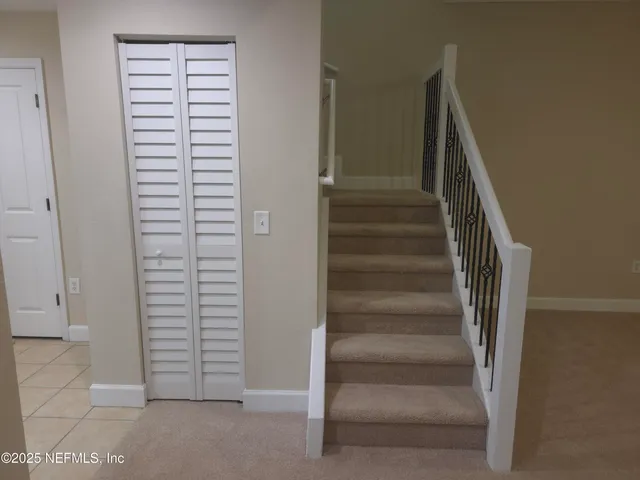 a view of staircase with white walls and white door